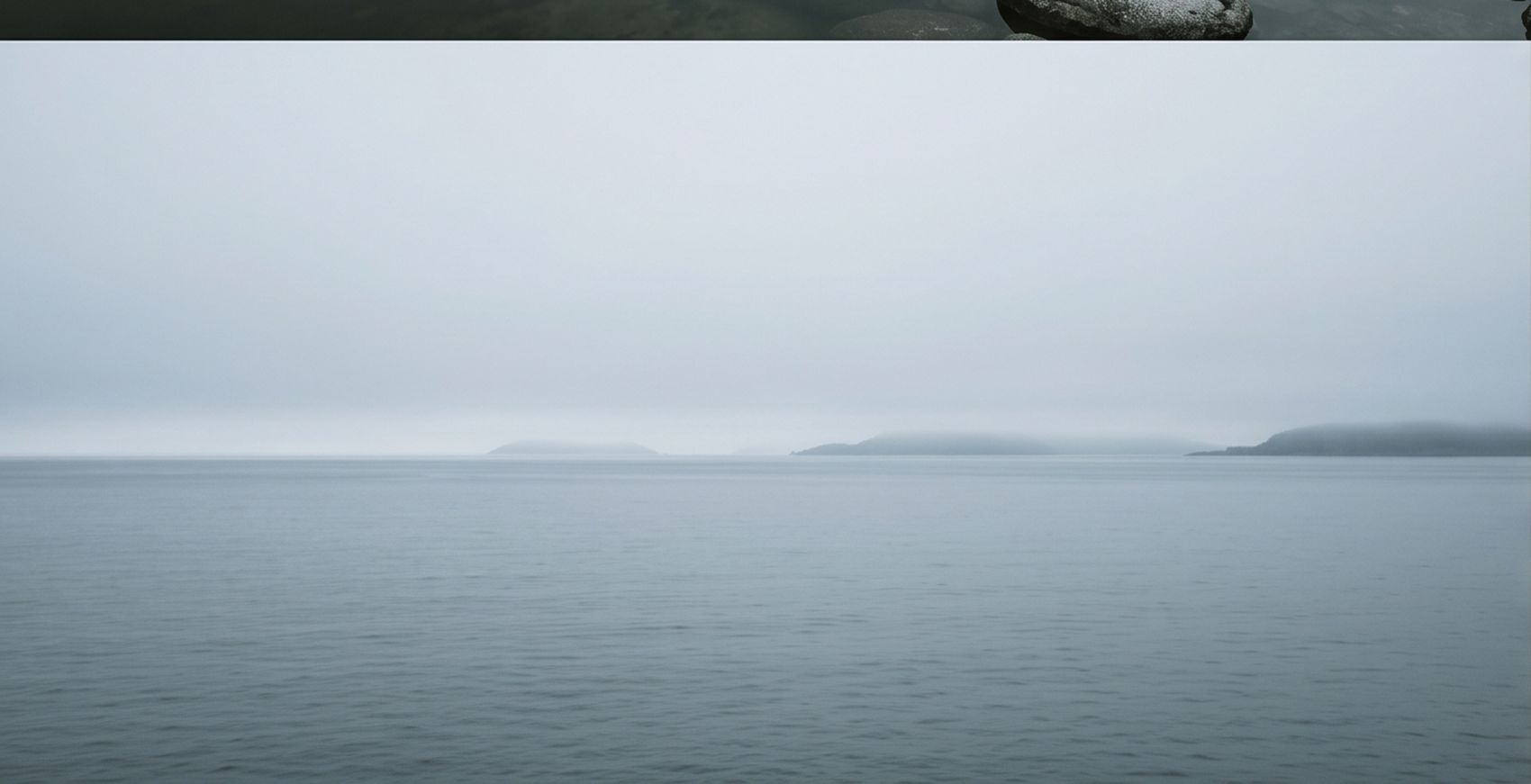 Une étendue d'eau calme et une ligne d'horizon dans la brume
